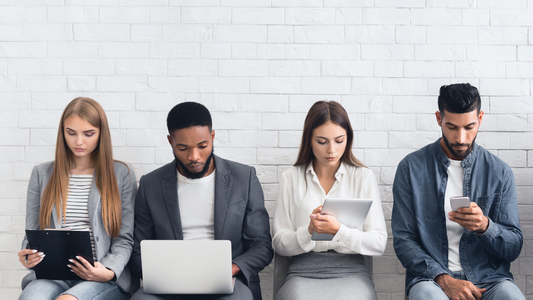 4 personas sentadas revisando cuadernos y computadoras